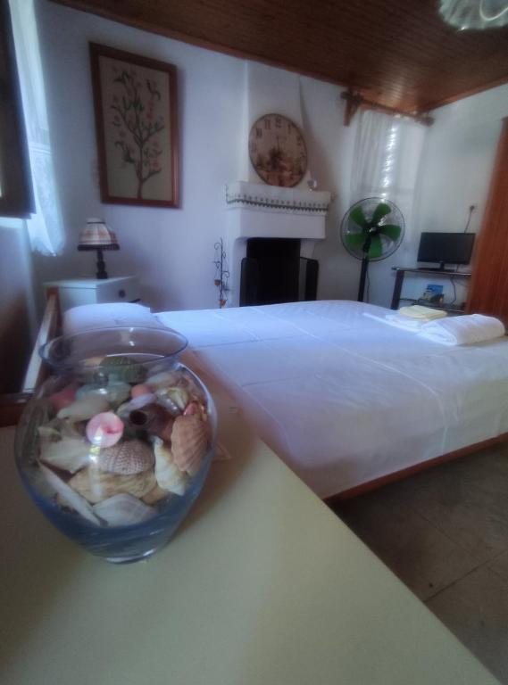 a bedroom with a bed and a bowl of shells at Trikeri traditional cozy house in Trikeri