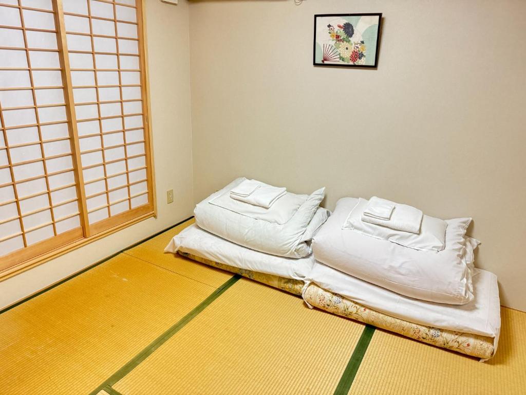 Cette chambre comprend 2 oreillers blancs au sol. dans l'établissement Ikoi no Ie - Vacation STAY 61470v, à Kyoto