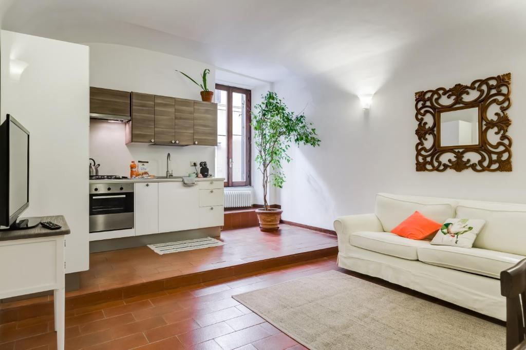 ローマにあるPurificazione 44 Guest Houseのリビングルーム(白いソファ付)、キッチンが備わります。