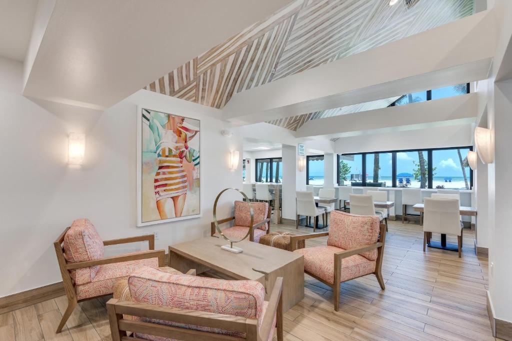 ein Wohnzimmer mit Stühlen und Tischen sowie ein Esszimmer in der Unterkunft Best Western Plus Beach Resort in Fort Myers Beach