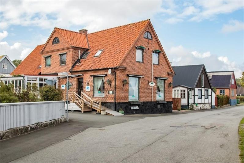 a large brick house with an orange roof on a street at Branteviks Bed o Breakfast in Brantevik