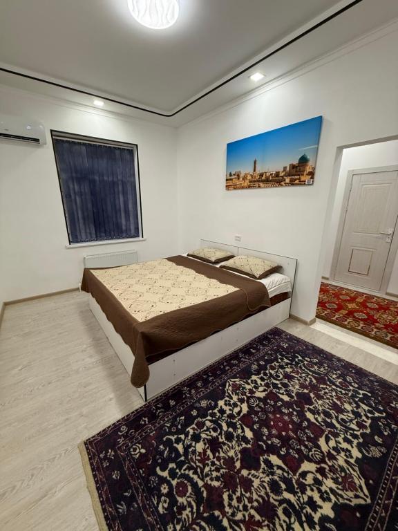 Un dormitorio con una cama grande y una alfombra. en KAMIR Guest House, en Bukhara