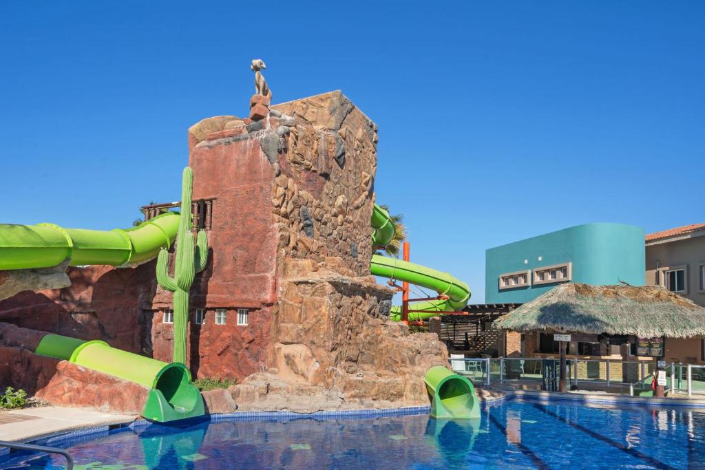 a pool with a water slide in a resort at Las Palmas 2BR 2BA Suite 3rd FL Ocean View- B301 in Campo del Medio