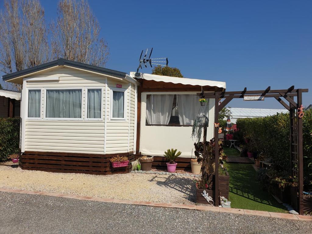 ein kleines Haus mit einer Pergola im Hof in der Unterkunft Camping le Montourey in Fréjus