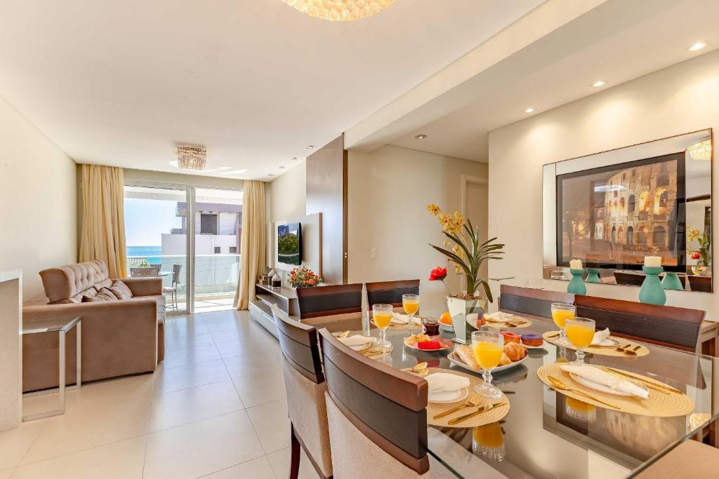 a dining room and living room with a table and chairs at Boulevard: Apto Exclusivo a Passos do Mar in Bombinhas