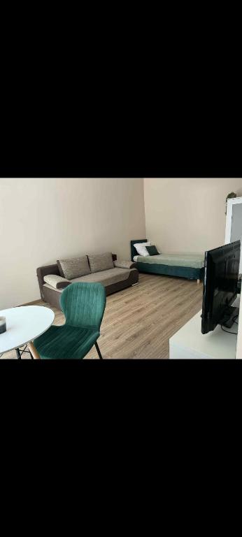 a living room with two beds and a television at Leśna Przystań in Pojezierze