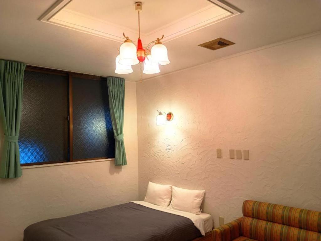 a bedroom with a bed and a chandelier at Hotel PUTIT BELL - Vacation STAY 57162v in Takahara