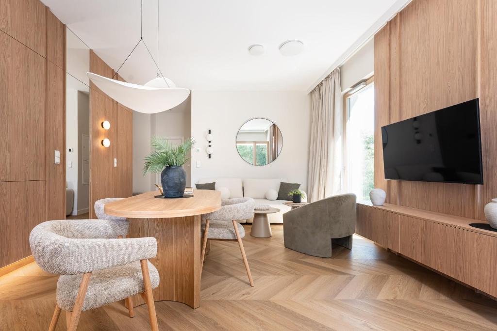 a living room with a table and chairs and a tv at Leśne spa przy Sopocie in Gdynia
