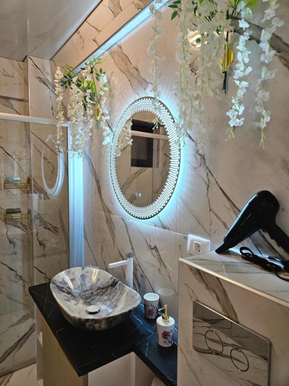 a bathroom with a sink and a mirror at EverGreen Apartment4 in Năvodari