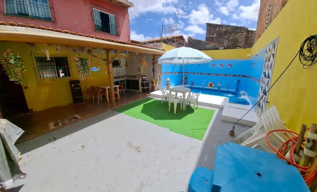 a patio with a pool and an umbrella at CASA Mosqueiro AMAZONIA BELÉM COP 30 in Belém