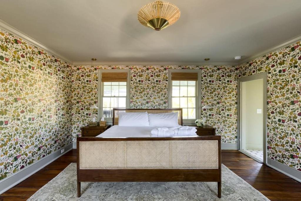 een slaapkamer met een bed en bloemenbehang bij The Nicholas Veranda King Suite - Walk to King in Charleston