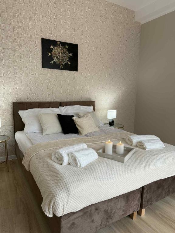a bedroom with a large bed with towels on it at Leśna Przystań in Pojezierze