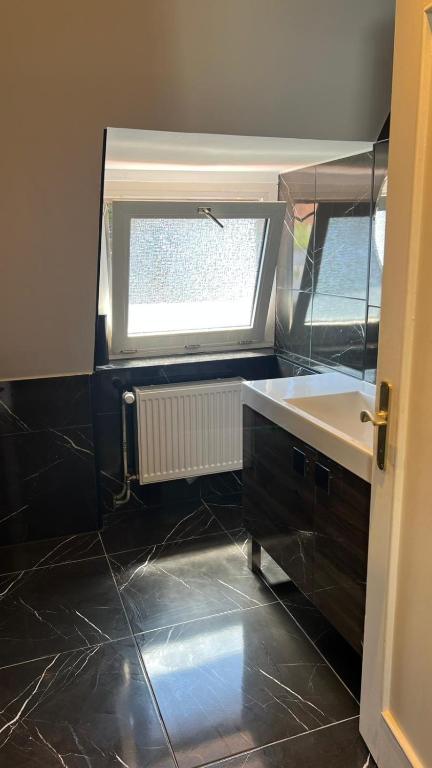 a bathroom with a sink and a window at Marlin City Apartment 2 in Bielefeld