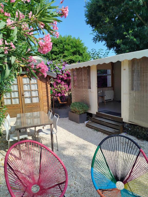 deux chaises colorées et une table dans un jardin dans l'établissement mobil home 4-6 places six fours les plages, à Six-Fours-les-Plages