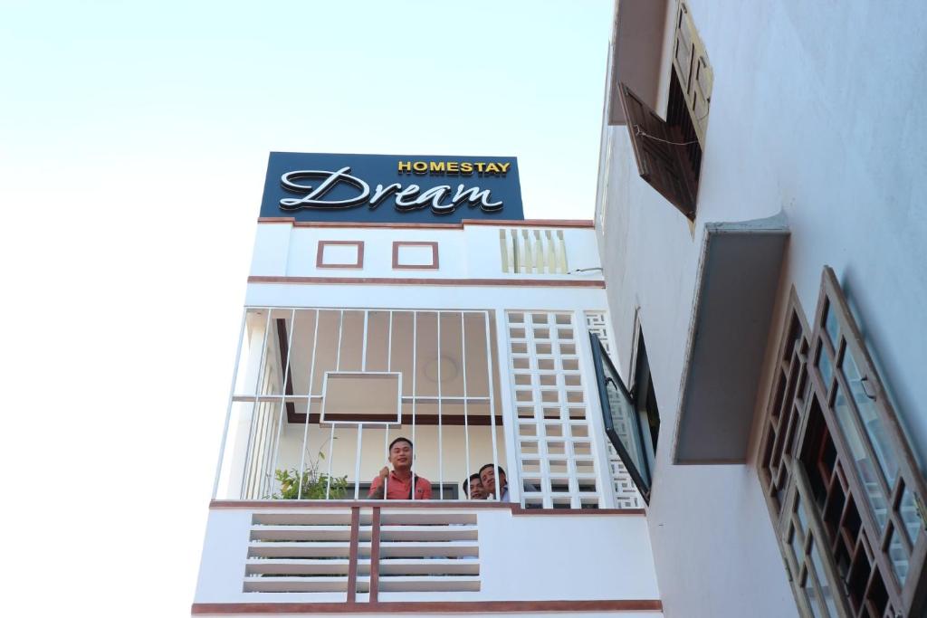 two people standing in the window of a building at Homestay Dream in Tuy Hoa