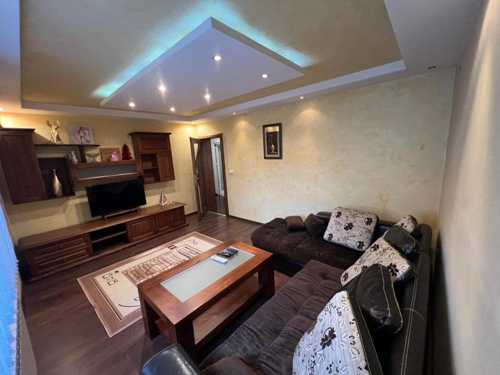 a living room with a couch and a tv at Къща Добринище in Dobrinishte