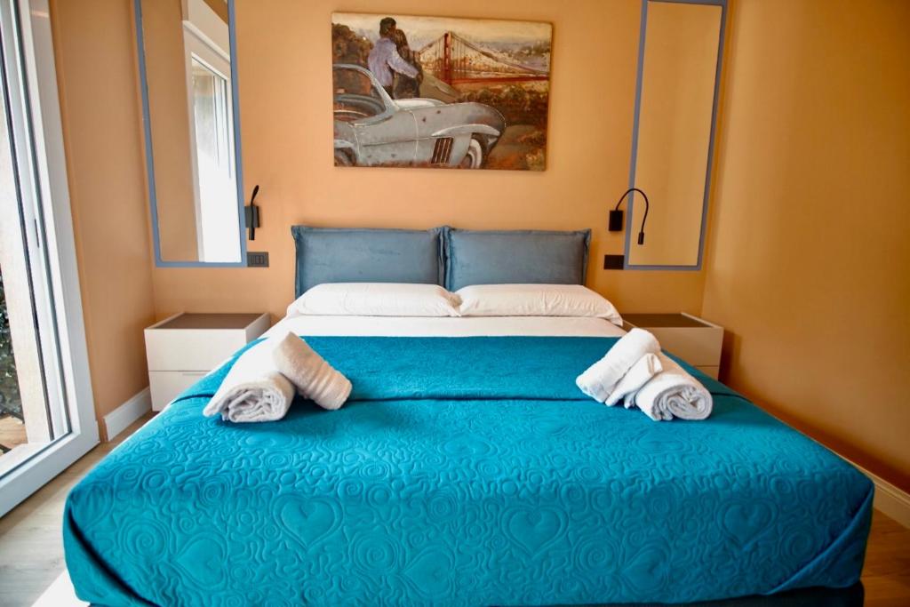 Un dormitorio con una cama azul con toallas. en Daisy Rooms Cinque Terre, en La Spezia