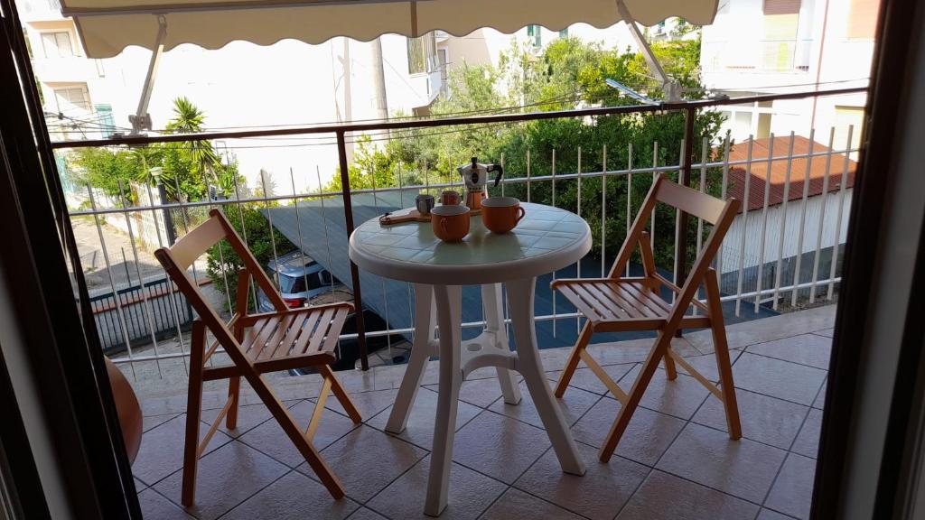 a white table and two chairs on a balcony at Finestra su Velia in Marina di Ascea