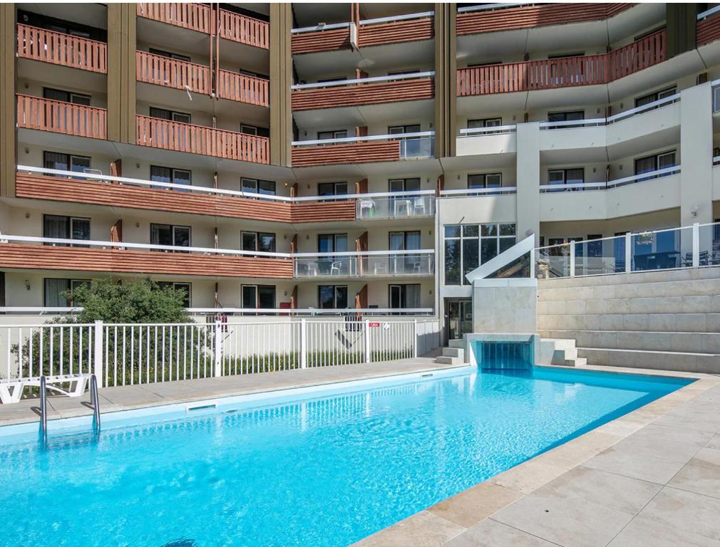 une piscine devant un immeuble dans l'établissement Appartement ALPE D HUEZ dans Résidence Pierre et Vacances Les Bergers, à Huez