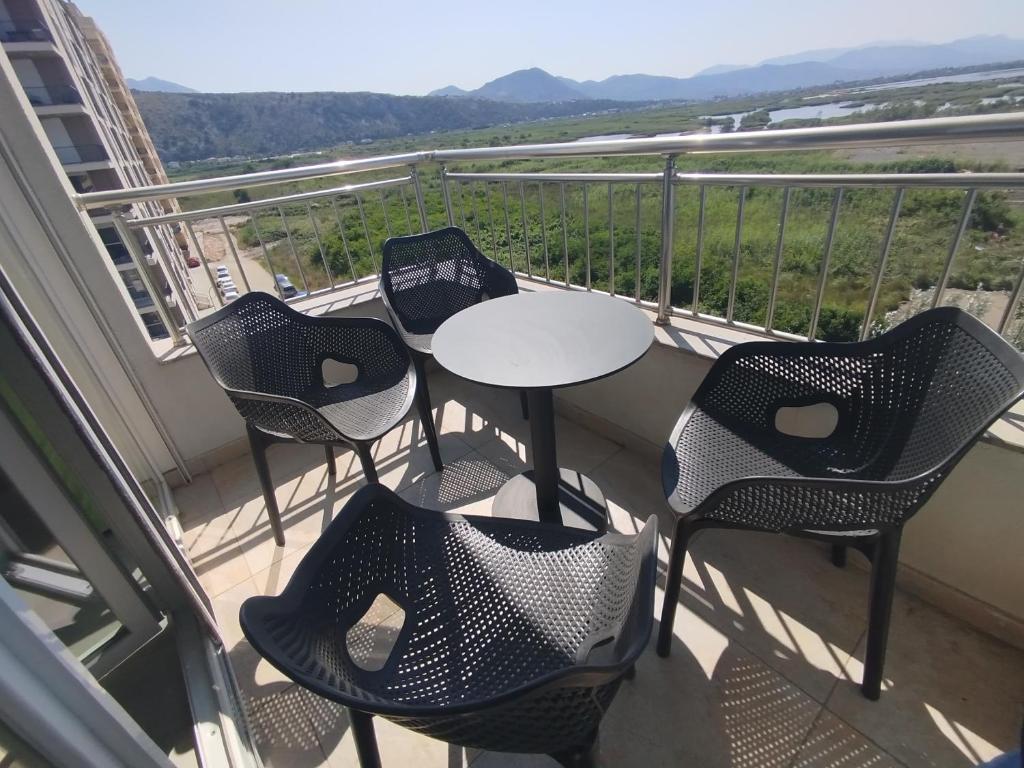 a balcony with four chairs and a table on it at U laguny 404 in Shëngjin