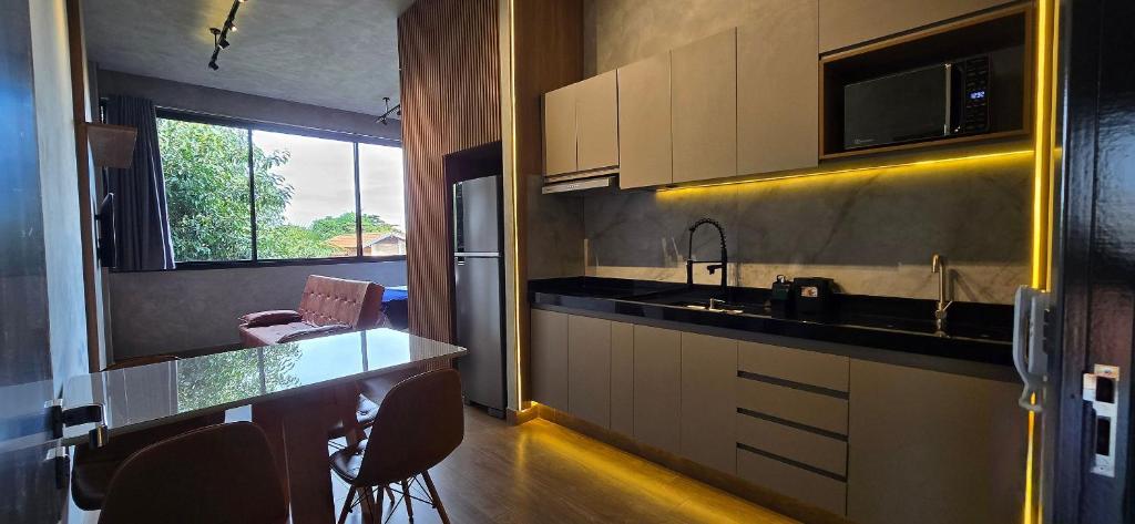a kitchen with a sink and a counter with chairs at City Zen Apartments in Sao Jose do Rio Preto