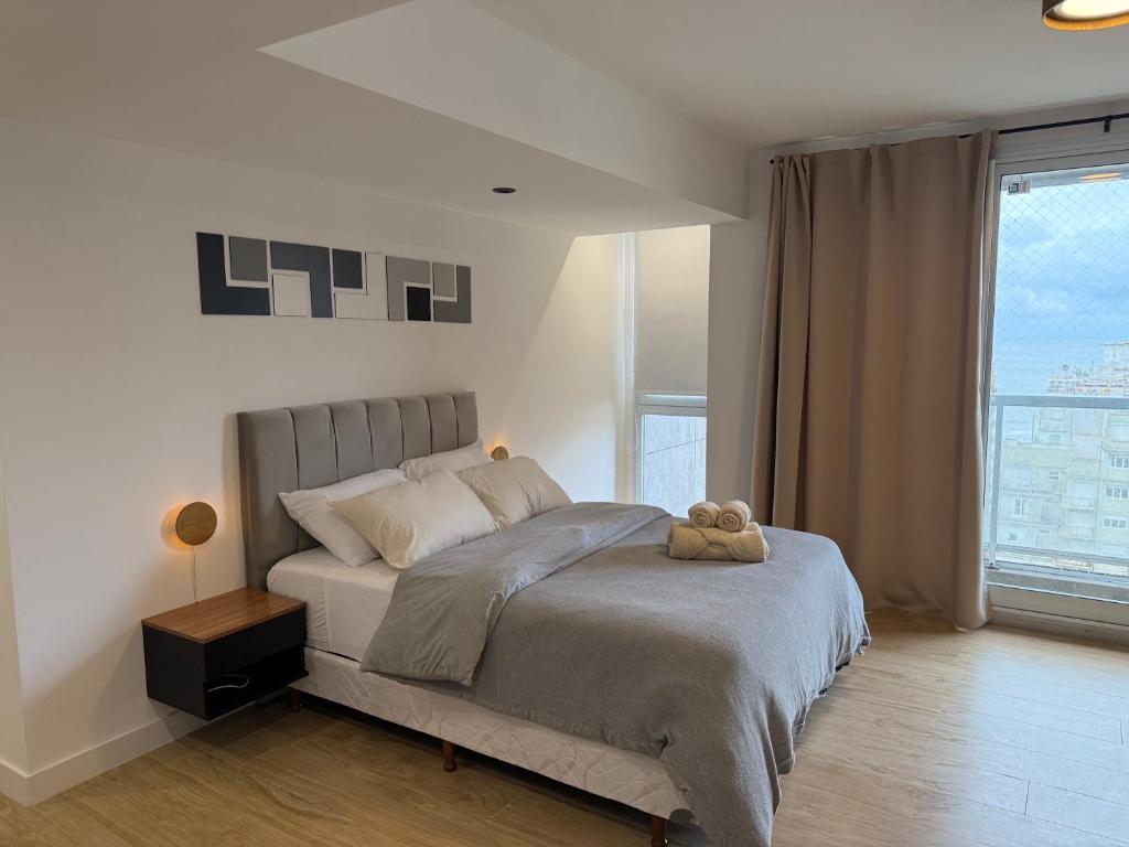 Un dormitorio con una cama con un osito de peluche encima. en MarDelSuites - Studio Premium Piso 14 a Pasos del Mar, Amenities, Seguridad 24hrs, Cochera Opcional, en Mar del Plata