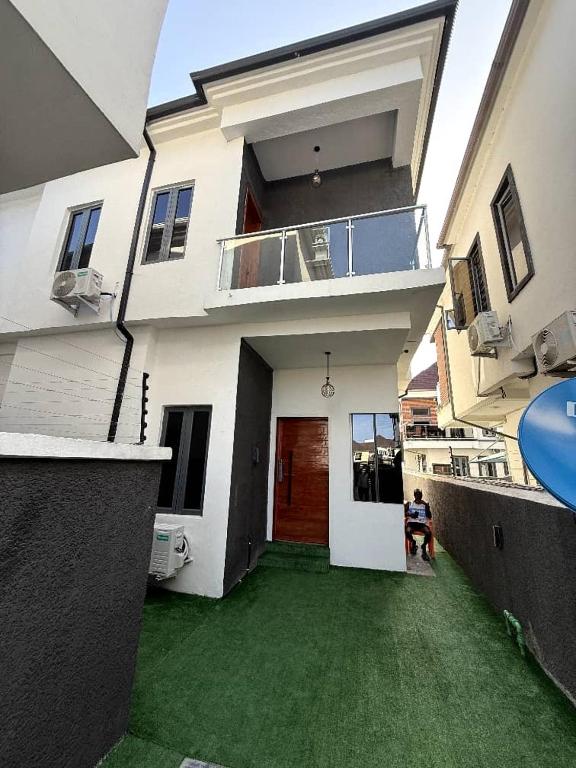 a large white house with a green yard in front of it at Four bedroom Luxury house Lekki in Lekki