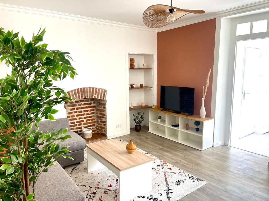 Una sala de estar con un sofá y un televisor. en Le refuge urbain - T2 à la gare, en Rennes