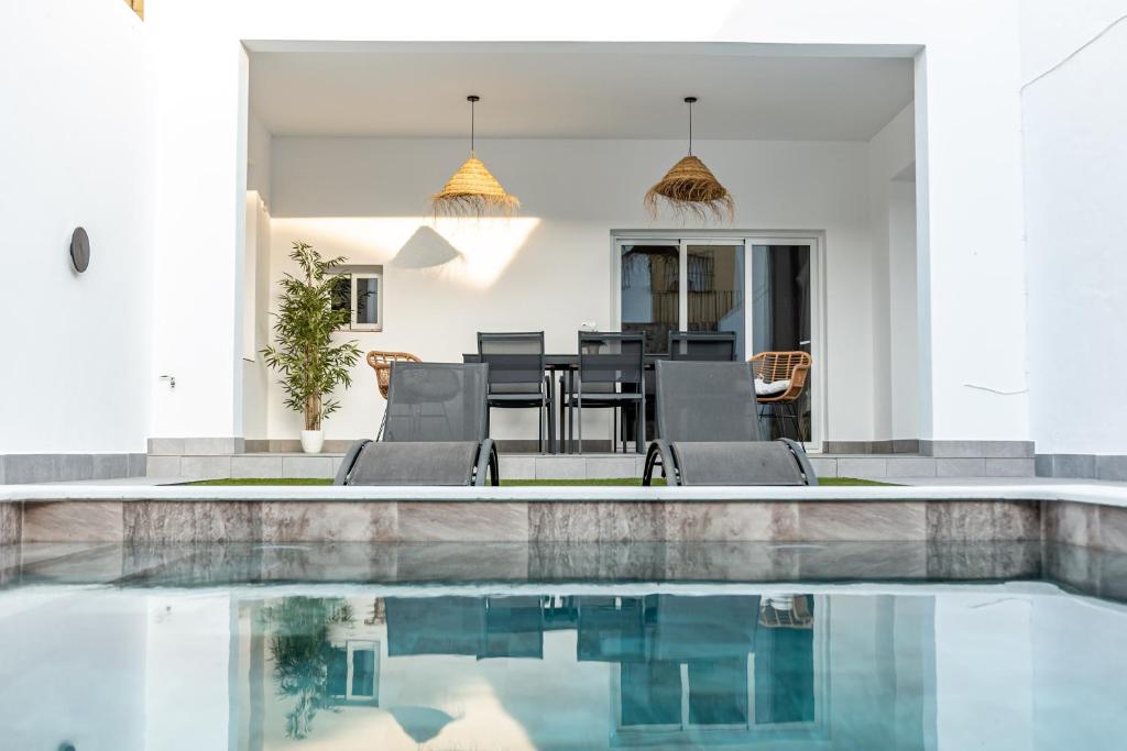 a house with a swimming pool and a dining area at Feeling Doñana in Villamanrique de la Condesa