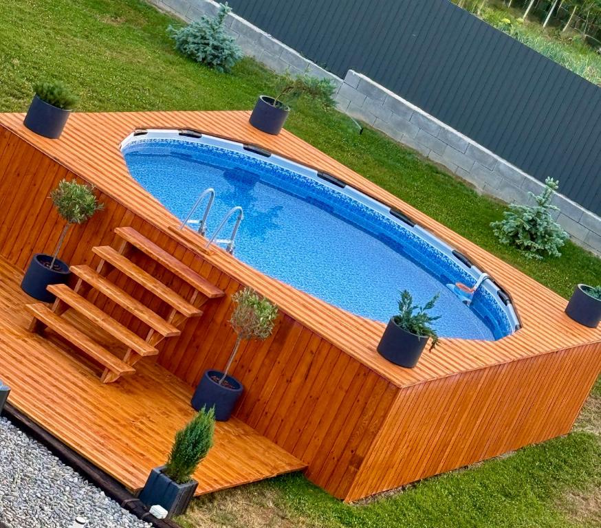 una vista dall'alto di una piscina con un ponte in legno di Hidden Cabin a Brezoi