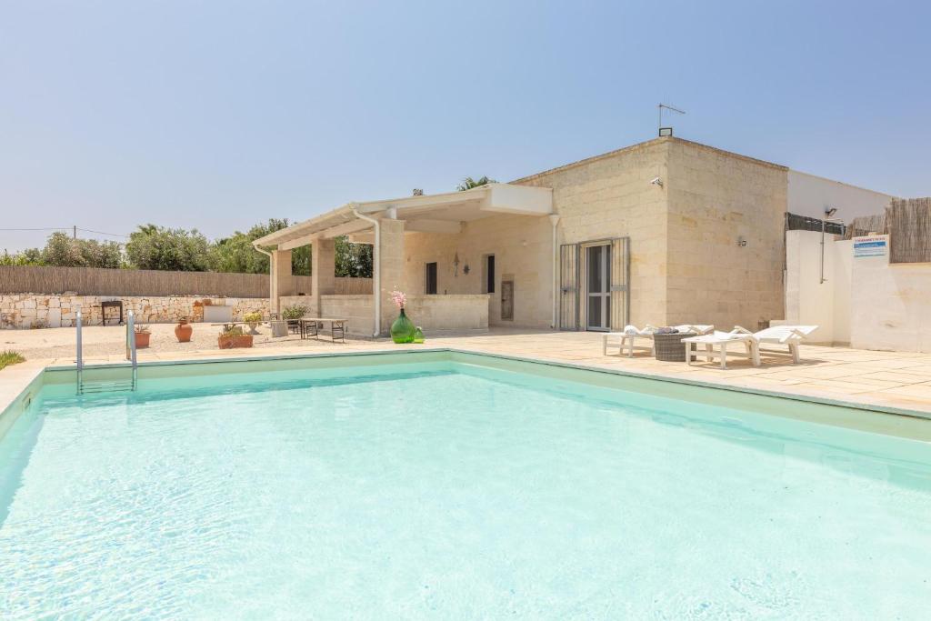 una gran piscina frente a una casa en Villa Serenella, en Carovigno