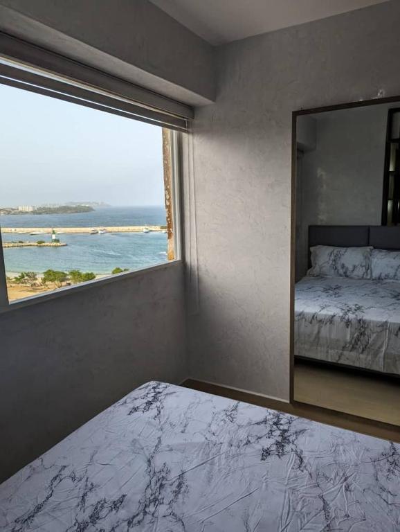 a bedroom with a mirror and a view of the ocean at Studio with Amazing Beach view in Porlamar