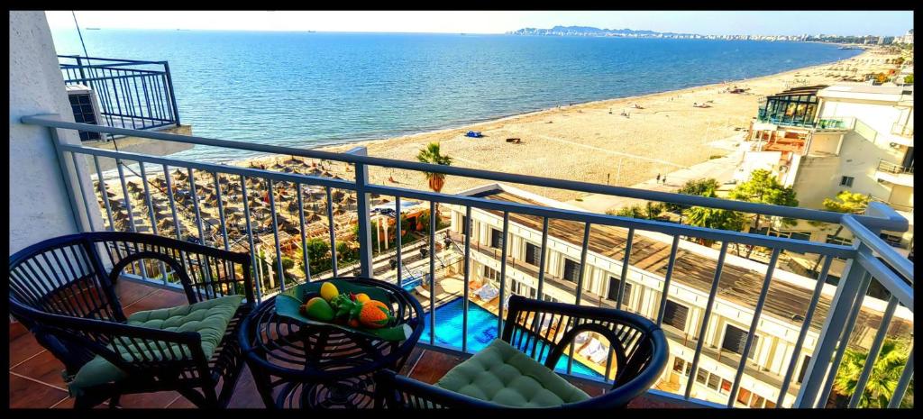 Un balcón con mesa y sillas y una playa. en Blue Apartment Kamelia, en Durrës