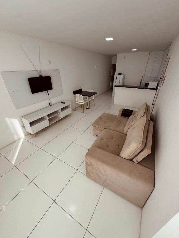 a living room with a couch and a tv at Nox Temporada Flat Completo em Caruaru com Ar e Wi-Fi Flat 101 in Caruaru
