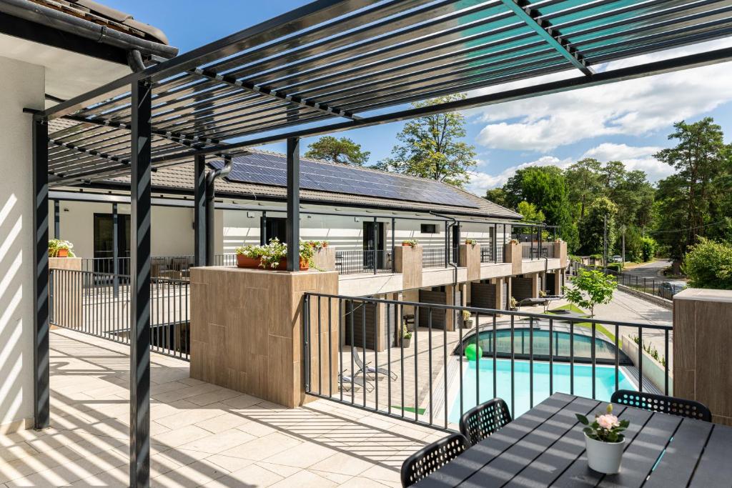 an outdoor patio with a pergola and a swimming pool at Balaton Flow Residence in Fonyód