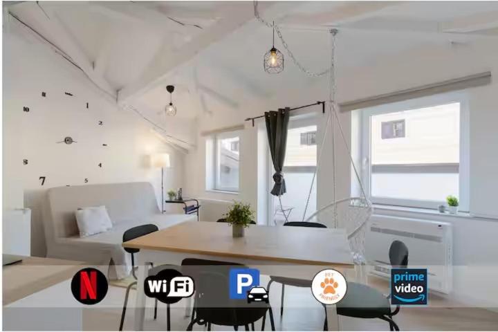 a living room with a table and chairs and a couch at Blake, attico centrale con parcheggio a Trieste in Trieste