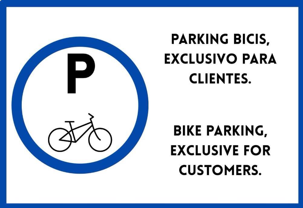 a sign for a bike parking sign with a bike parked for customers at Betalia II in Caldas de Reis