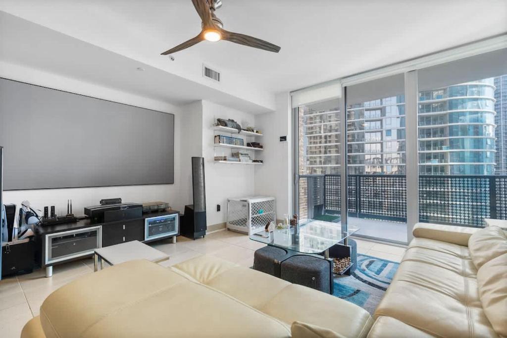 a living room with a couch and a flat screen tv at Brickell LuxePad 1BED 1BATH with Pool, Gym, Sauna, Grills, Cinema Projector in Miami