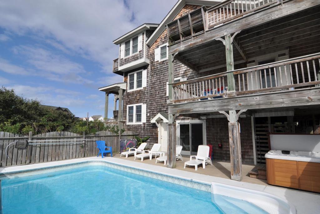 a swimming pool in front of a house at Curlews Call in Nags Head