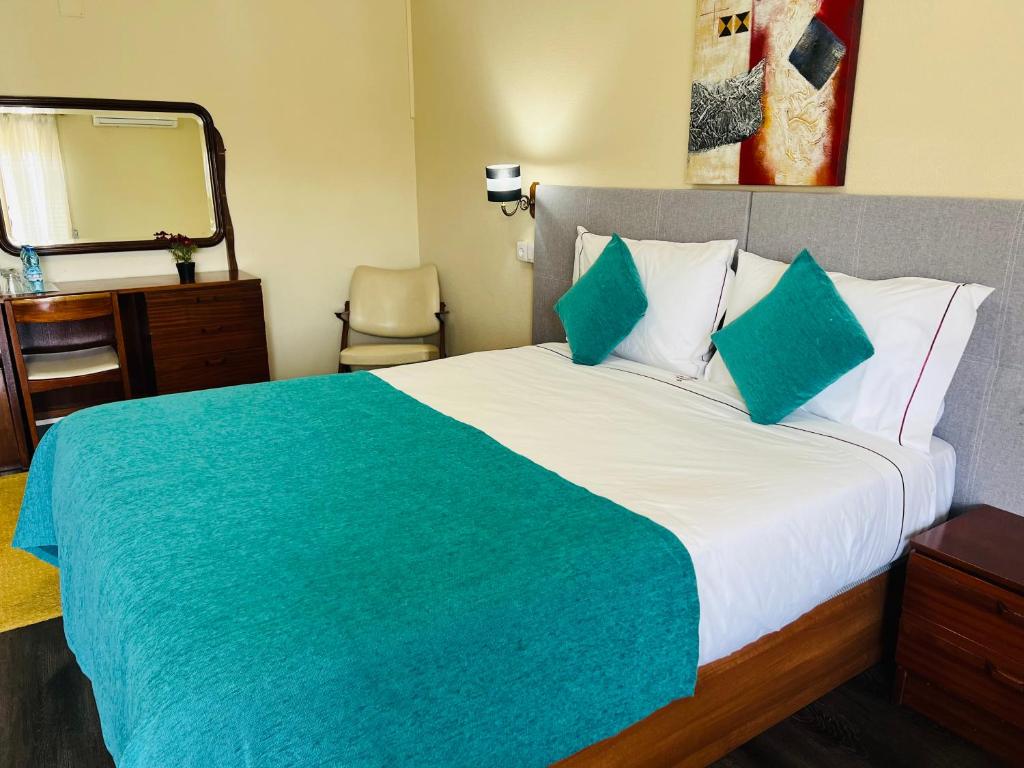 a bedroom with a large bed and a mirror at Hotel Colmeia in Monte Real