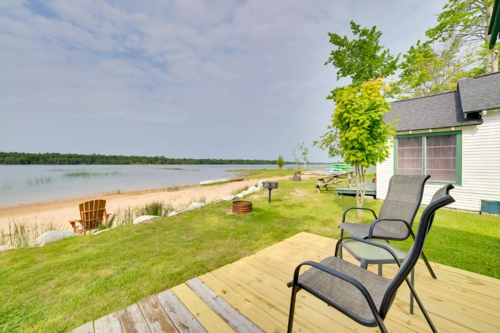 two chairs sitting on a deck near a body of water at Les Cheneaux Islands Retreat 2 Boat, Fish and Swim in Cedarville