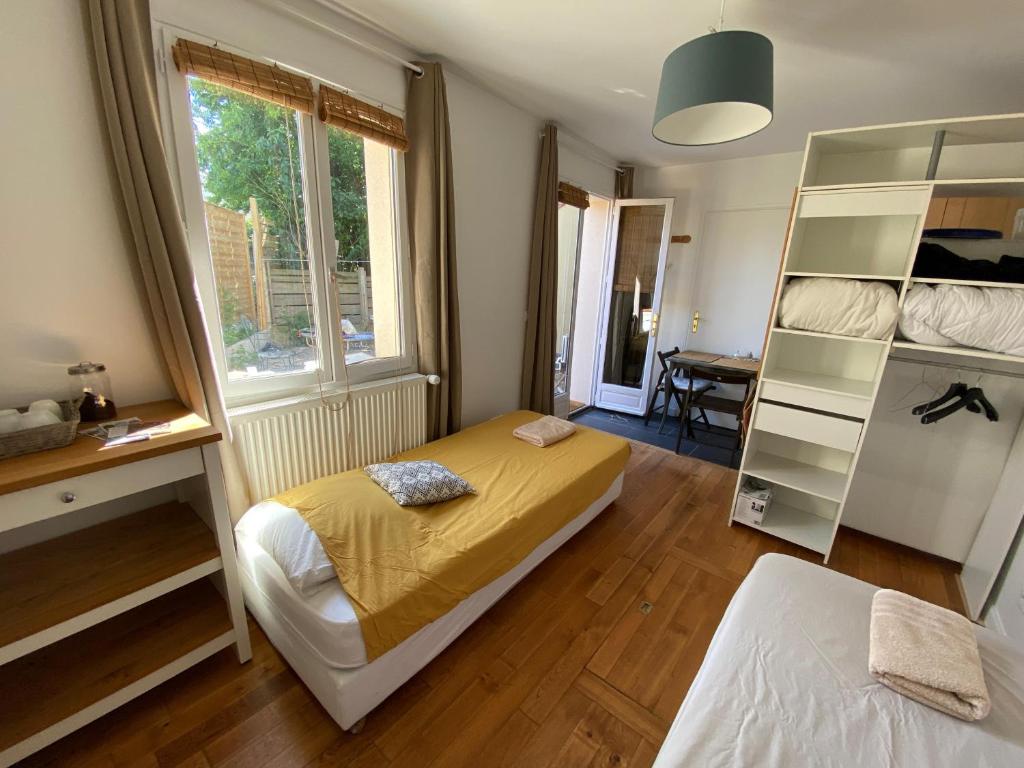 - une chambre avec 2 lits, une étagère et une fenêtre dans l'établissement ideally located next to castle park, à Saint-Cyr-lʼÉcole