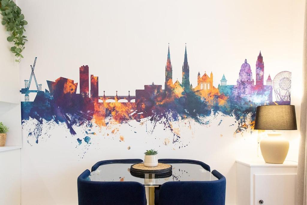 a table and a chair in a room with a painting at The Belfast Snug in Belfast