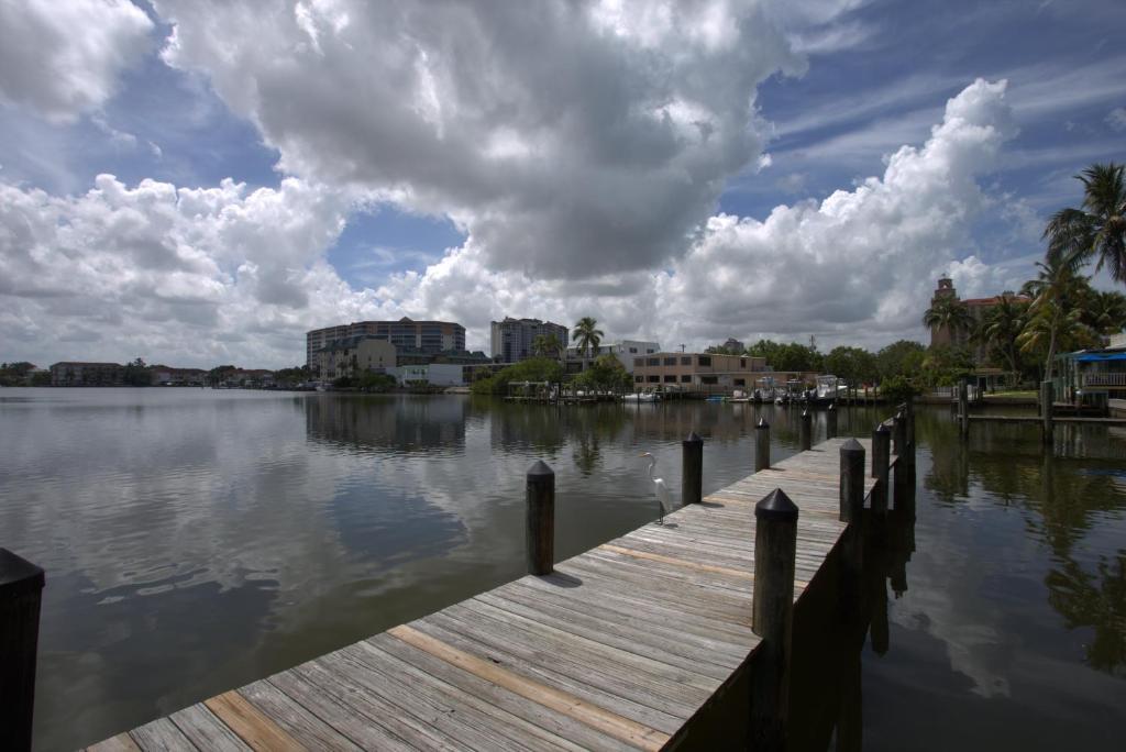 a dock on a body of water with buildings at Vanderbilt Beach Resort in Naples
