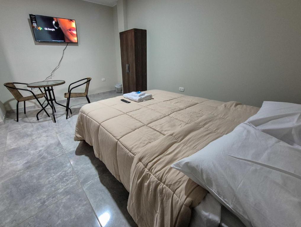 a bedroom with a bed and a table and a tv at Mablia Suite in Ica