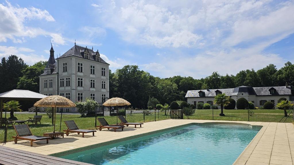 a house with a swimming pool in front of a building at Gîtes du Château de Malcombe in Rillé
