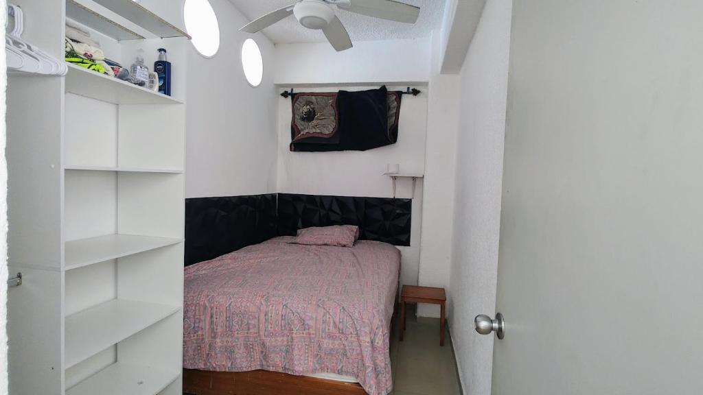 ein kleines Schlafzimmer mit einem Bett und einem Schrank in der Unterkunft Departamento en el piso 18 in Acapulco