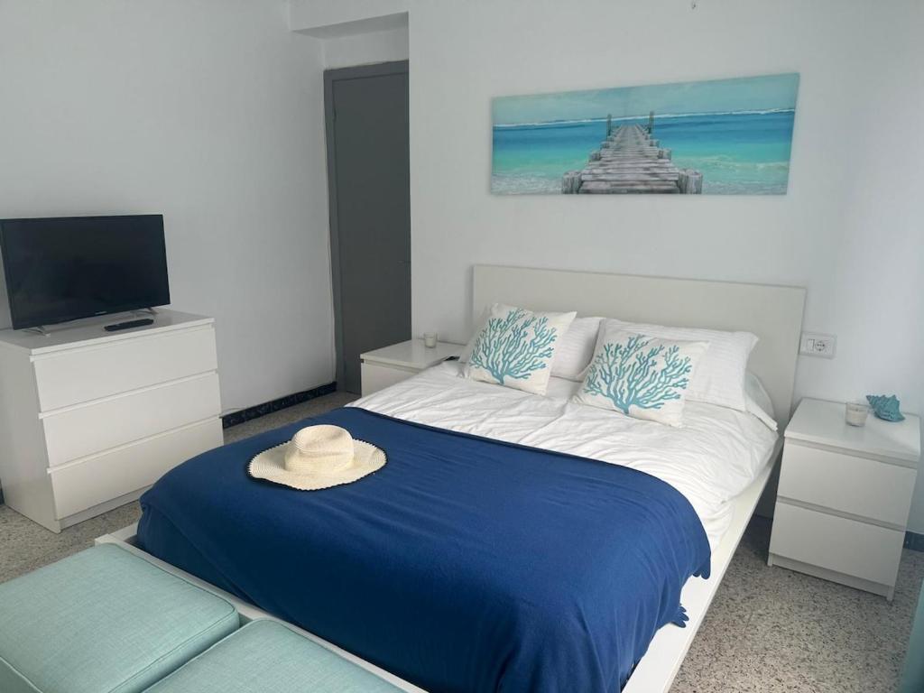 ein Schlafzimmer mit einem Bett, auf dem ein Hut liegt in der Unterkunft Piso céntrico cerca de la playa Cedeira in Cedeira