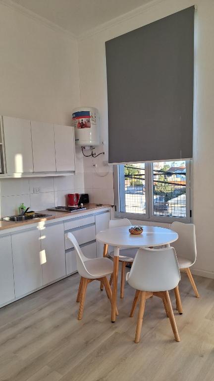 une cuisine avec une table et des chaises dans une cuisine dans l'établissement Departamentos Espejo Dpto A, à Concordia