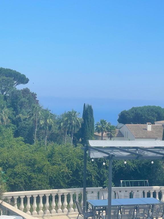 une table et des chaises avec un parasol sur une terrasse dans l'établissement Villa avec piscine vue sur la mer, à Cannes